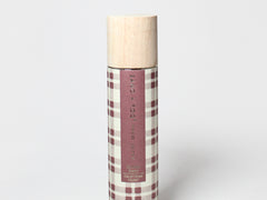 Cylindrical room spray bottle with plaid label and light wood cap